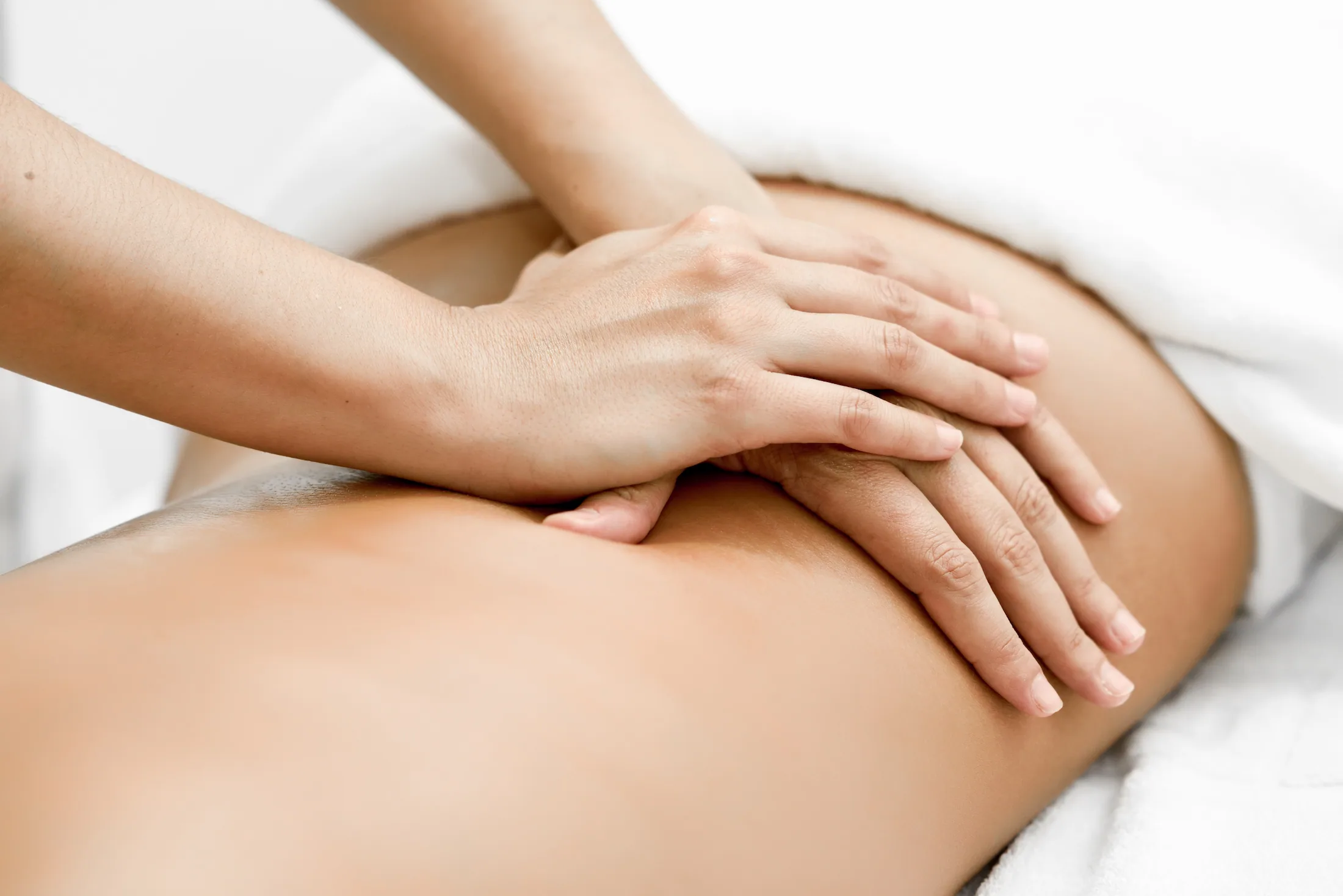 Therapist's hands performing massage on a client's leg